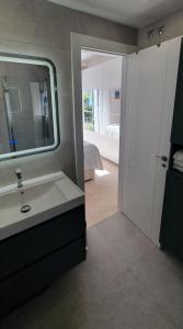 a bathroom with a sink and a mirror and a bedroom at Costalita Seaview in Estepona