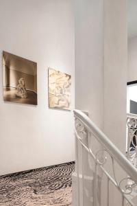 uma escada branca com dois quadros na parede em Hotel GIN Budapest em Budapeste