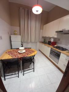 eine Küche mit einem Tisch und einigen Stühlen sowie einem Tisch und einer Küche in der Unterkunft Milazzo23 in Rom