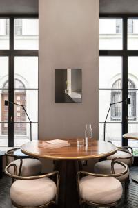 a table and chairs in a room with windows at Hotel GIN Budapest in Budapest