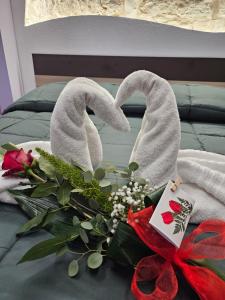 a bed with towels and a bouquet of flowers at LUXUITE SPA con PISCINA e JACUZZI in Alberobello