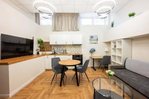 a kitchen and living room with a table and chairs at Krasiński Garden Apartments in Warsaw
