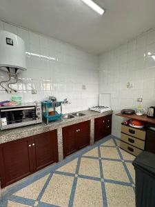 a kitchen with a sink and a microwave at Sea Surf and Sun in Tamraght Ouzdar