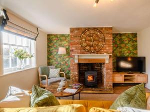 a living room with a fireplace and a tv at 2 Bed in Foulsham 90675 in Foulsham