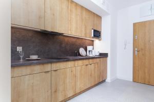 a kitchen with wooden cabinets and a sink at Aquamarina Prima 049 by Renters in Międzyzdroje