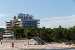 a group of people on a beach with a building at Aquamarina Prima 049 by Renters in Międzyzdroje