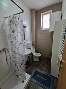 a bathroom with a toilet and a shower curtain at Tami in Belgrade