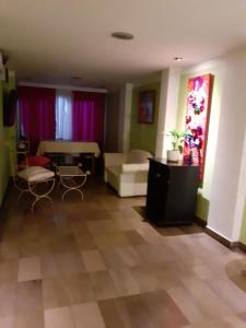 - un salon avec un canapé, un lit et des rideaux violets dans l'établissement Hotel Alvear Jujuy, à San Salvador de Jujuy