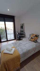 a bedroom with a large bed with a chair and windows at LC Plaza del Pilar in Zaragoza