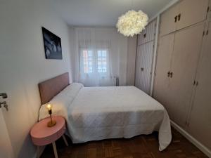 1 dormitorio con 1 cama y 1 mesa con lámpara en CASA SÁDABA, en Ávila