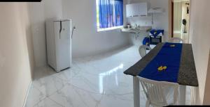 a kitchen with a table with two chairs and a refrigerator at Pousada Miranda 1 in Ibitirama