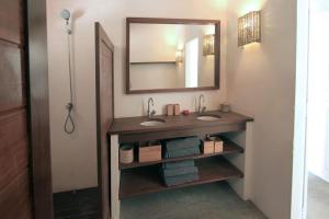 uma casa de banho com 2 lavatórios e um espelho em Villa Shanti em Atins