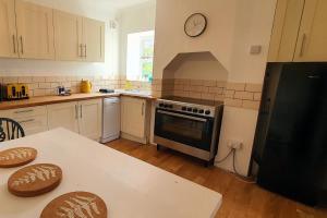 a kitchen with a black refrigerator and a table at End Cottage, Bakewell in Bakewell