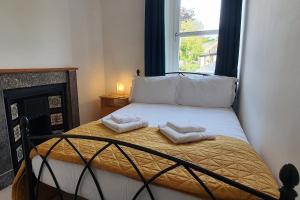 a small bedroom with a bed with two towels on it at End Cottage, Bakewell in Bakewell
