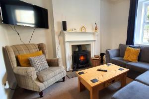 a living room with a couch and a fireplace at End Cottage, Bakewell in Bakewell