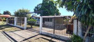 a white fence with a gate in a yard at Tu casa lejos de tu casa in David