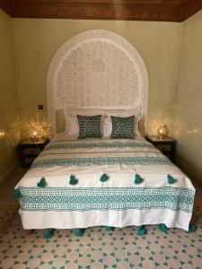 a bedroom with a large bed with a white headboard at Riad Amalia in Marrakech