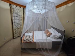 a bedroom with a bed with a mosquito net at Top of the World Lodges Fort Portal in Fort Portal