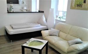 ein Wohnzimmer mit einem Sofa und einem Tisch in der Unterkunft Citywohnung im Paulusviertel II in Halle an der Saale
