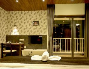 een slaapkamer met een bed met handdoeken erop bij Hotel Limelight in Kudāl