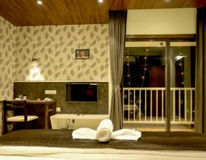 a bedroom with a bed with towels on it at Hotel Limelight in Kudal