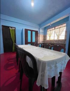 a dining room with a white table and chairs at GREEN HILLS in Cherrapunji +22 photos