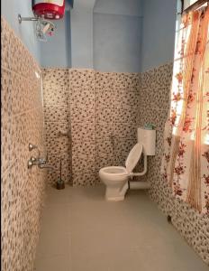 a bathroom with a toilet and a shower curtain at GREEN HILLS in Cherrapunji