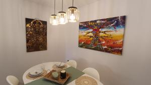 a dining room with a table and two paintings at LC Plaza del Pilar in Zaragoza