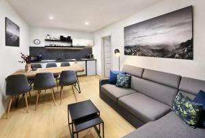 uma sala de estar com um sofá e uma mesa em Sky-House Jasná Apartments em Pavčina Lehota