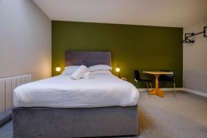 een slaapkamer met een groot bed en een groene muur bij Station Lodge - FREE off-site Health Club access with Pool, Sauna, Steam Room & Gym in Windermere