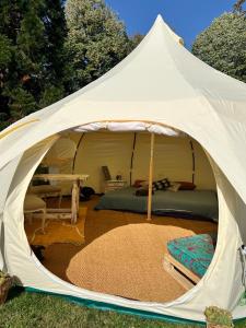 ein weißes Zelt mit einem Bett und einem Tisch in der Unterkunft Dealettante glamping in Bétaucourt