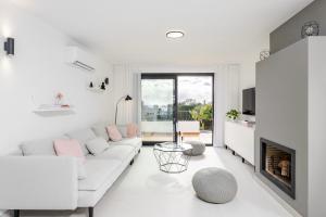 Biały salon z białą kanapą i kominkiem w obiekcie Modern Beachside Townhouse in Costalita - with Sea Views! w mieście Estepona