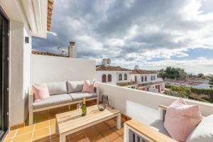 balkon z kanapą i widokiem na miasto w obiekcie Modern Beachside Townhouse in Costalita - with Sea Views! w mieście Estepona