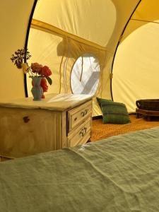 a tent with a table with a vase of flowers at Dealettante glamping in Bétaucourt