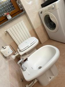 a bathroom with a toilet and a washing machine at Sweet Home in Lissone