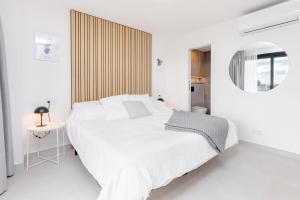 biała sypialnia z dużym łóżkiem i lustrem w obiekcie Modern Beachside Townhouse in Costalita - with Sea Views! w mieście Estepona
