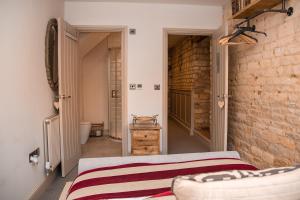 um quarto com uma cama e uma parede de tijolos em No.4 The Old Coach House em Blockley