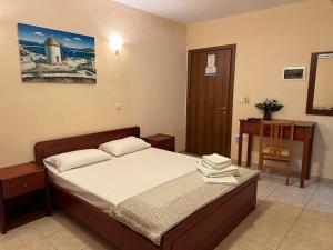 ein Schlafzimmer mit einem Bett und einem Tisch und einer Tür in der Unterkunft VILLA ELENI in Skala Marion