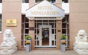 einen Hoteleingang mit zwei Löwen vor einem Gebäude in der Unterkunft Hotel Mingarden in Düsseldorf