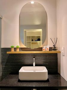 Nari Guest Room في فرناندو دي نورونها: حمام مع حوض أبيض ومرآة