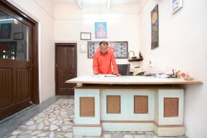 a man standing at a counter in a room at OYO Flagship Hotel Divine Light in Bhiwāni
