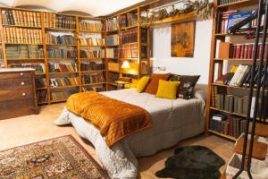 1 dormitorio con cama y estanterías de libros en Mas Gran de Cruïlles - Mas Rural - Hotel & Events en Cruïlles