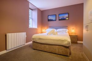 a bedroom with a large bed and two windows at Station Lodge - FREE off-site Health Club access with Pool, Sauna, Steam Room & Gym in Windermere