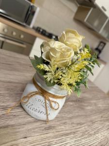 a vase filled with yellow roses on a table at Sweet Home in Lissone