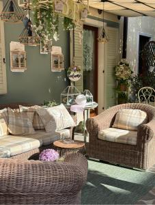 um pátio com 2 cadeiras de vime e uma mesa em B&B Sul Garda em Castelnuovo del Garda