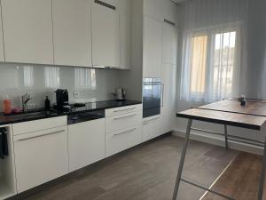 uma cozinha com armários brancos e uma mesa em Grosse Einzimmerwohnung/Büro/Showroom em Seengen