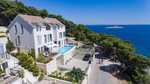 a house with a swimming pool next to the ocean at Villa Madeleine Hvar in Hvar