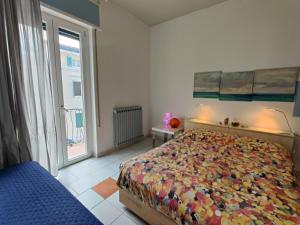 um quarto com uma cama e uma grande janela em Appartamento al mercato: Viareggio em Viareggio