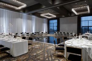 a ballroom with tables and chairs in a room with windows at Delta Hotels by Marriott Dallas Southlake in Southlake