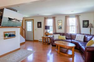 a living room with a leather couch and a table at Stay On The Cape Vacation Rentals: Book Eastham Plenty Of Room For Entire Family in Eastham